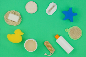 Washcloths, shampoo and other accessories in green background. Copy space. Top view.