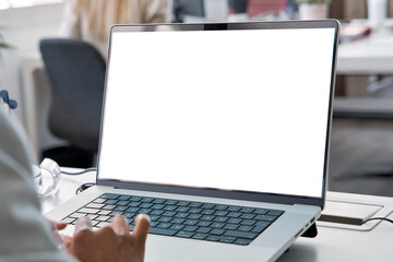 Young business woman working on laptop with blank copy space screen for ad app in modern busy...