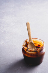 Caramel jam and spoon on vintage background