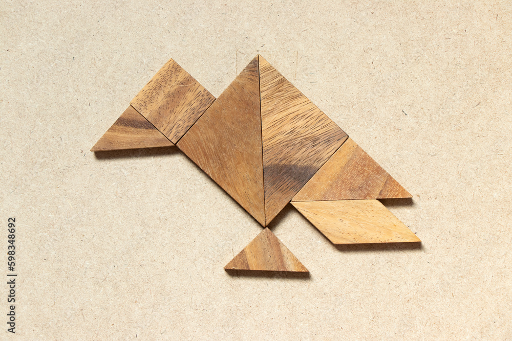 Wall mural Wooden tangram in vulture bird shape on wood background