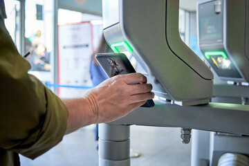 person scanning smartphone on a security control pass machine to entrer in a secured area - obrazy, fototapety, plakaty