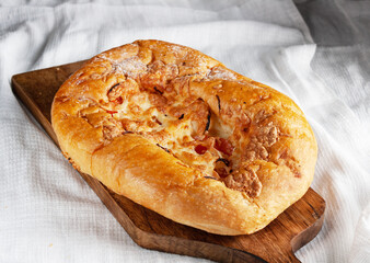 bread with cheese and tomatoes on a wooden board, close-up, copy space
