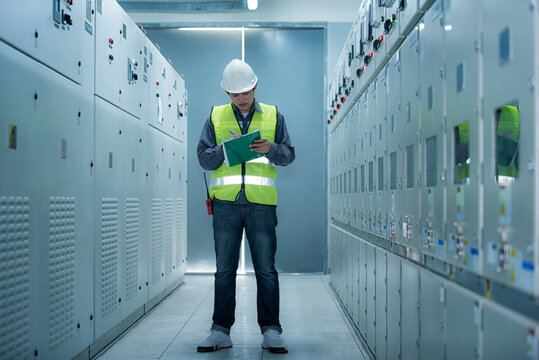 electrician working in a factory. electrician at work. electrician working in a power station. engineer working on the checking status switchgear electrical energy distribution substation