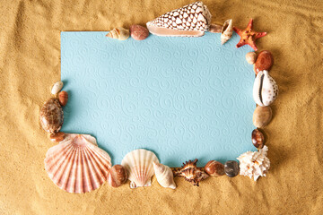 Invitation or greeting card mockup in frame of seashells and starfish on the ocean sandy beach...
