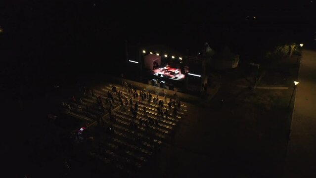 End of a show concert open space night audience people leaving. Aerial drone shot.
Outdoor exterior stage music concert at night. Stage lights and audience standing ovations.