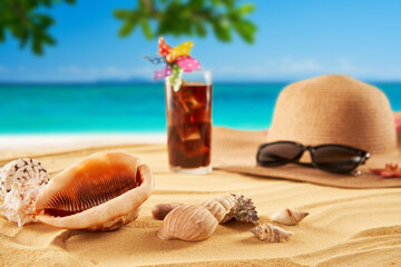 Straw hat, sunglasses and cocktail on the sand and sea background. Relax on the beach
