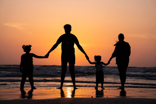 Beautiful Family standing on beach watching and enjoying the sunset view, Happy family concept image,  international day of families