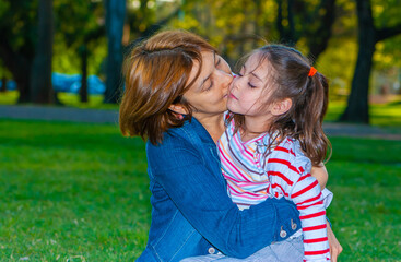 Happy mother with daughter on the lawn in the park