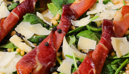 cold dish made with sliced bresaola flakes of grana cheese and green rocket leaves - obrazy, fototapety, plakaty