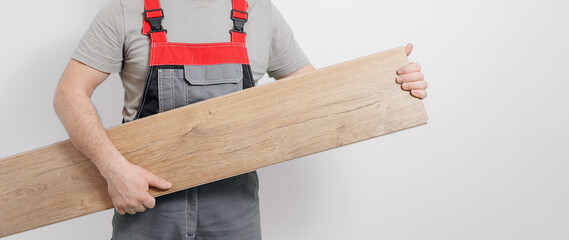 Professional builder with laminate or wooden parquet on white background banner