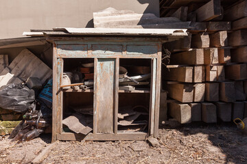 Broken kitchen cabinet in the backyard. Backyard with building rubbish. Rural courtyard