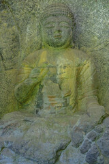Fototapeta na wymiar Usuki, Japan - May 1, 2023: Detail of one of the Usuki Stone Buddhas. They are a set of sculptures carved in rock during the 12th century in Usuki, Japan.