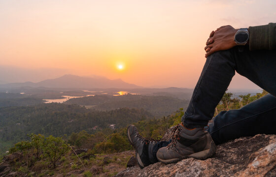 Young men sitting on the mountain and watching the sunset , Relaxing and traveling concept image