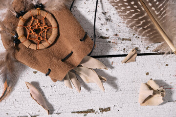 White Sage leaves (Salvia apiana) in a medicinal pouch and incense feather on old white wood....