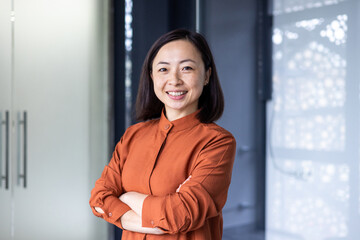 Portrait of young beautiful and successful Asian business woman, female employee smiling and...