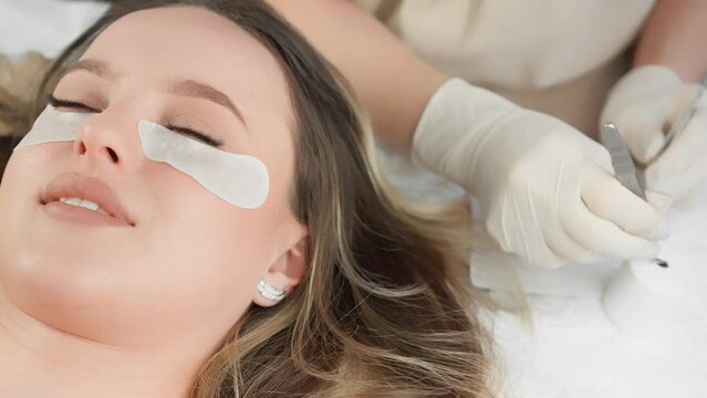 Gentle touch and impeccable technique of the master during eyelash extensions for maximum effect. Beautician, lashmaker in beauty clinic. Relaxation and relaxation under yaas treatments Generative AI