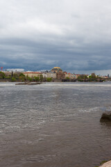 Fototapeta premium HDR of Vltava Moldau river in Prague with dark sky. The river passes in the middle of the city center, the sky is dark threatening, cruise ships for tourists roam the river.