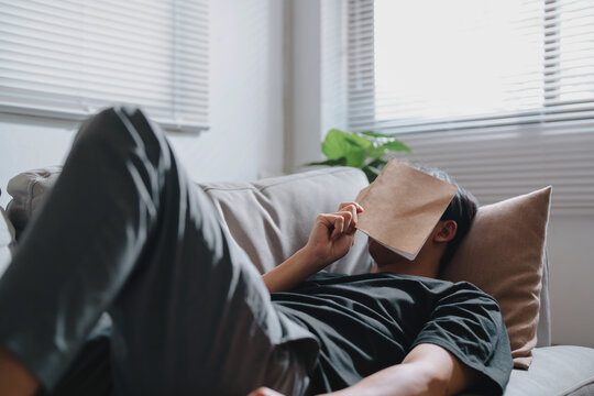 Exhausted Young Man Fell Asleep On Sofa At Living Room..