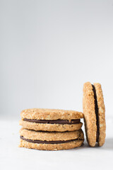 oat cookies with chocolate filling, homemade oatmeal cookies filled with chocolate ganache, thin oat biscuits with chocolate ganache