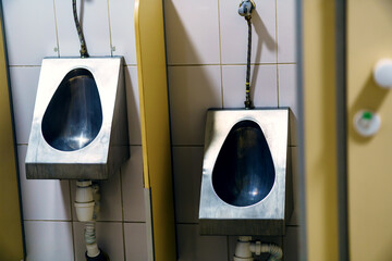 Metal urinals for adults and children in a public toilet