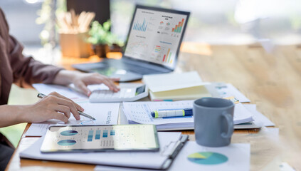 Financial Businesswomen analyze the graph of the company's performance to create profits and...