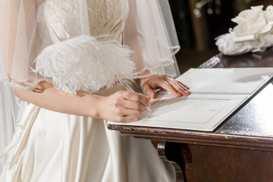 結婚証明書にサインをする新婦の手元