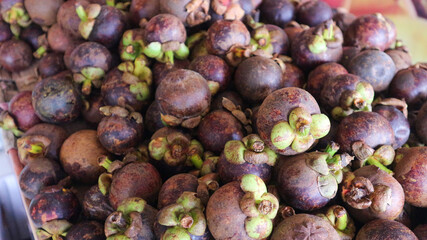 pile of fresh mangosteen fruit on display in supermarket, market, shop, or grocery
