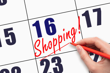 16th day of the month. Hand writing text SHOPPING and drawing a line on calendar date.