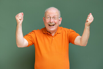 Happy grey haired senior man with mustache wearing eyeglasses with arms raised