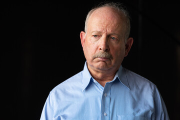 Fototapeta premium Grey haired senior man with mustache looking sad and stressed
