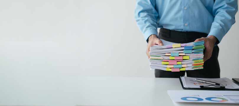 Close up view of businessman working with stack of document papers on the table.
