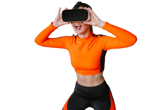 Excited Caucasian girl in orange sportswear using virtual reality headset with wide opened mouth against transparent background. Technologies, sport. For caucasian brunette girl trains by vr glasses