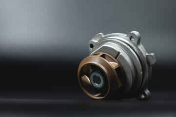 Close-up Automotive water pump, pump for pumping the coolant of the truck, part of the car engine cooling system. Black background, close-up, selective focus