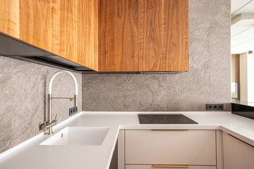 horizontal frame of the kitchen, white sink, wooden facades, gray wall, induction cooker