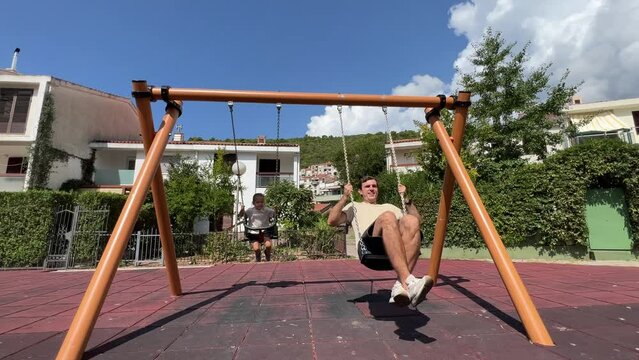 Dad with a little girl swing on swings in the playground Generative AI