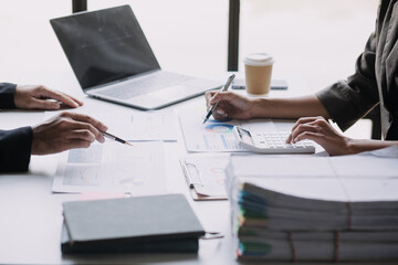 Financial analysts analyze business financial reports on a digital tablet planning investment project during a discussion at a meeting of corporate showing the results of their successful teamwork.