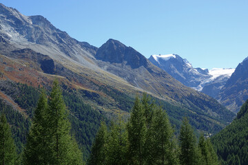 Italian Alps in Aosta Valley with high peaks and colorful trees