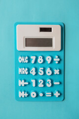 Fun kid's blue calculator on light blue background for childhood mathematics education or tax accounting