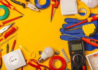 Electrician equipment on yellow background with copy space.Top view.Electrician tool set.Multimeter, tester,screwdrivers,cutters,duct tape,lamps,tape measure and wires.Flet lay. © Avocado_studio