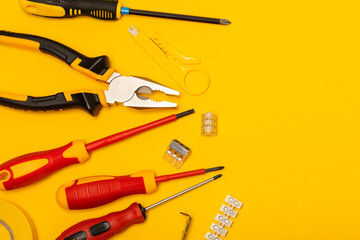 Electrician equipment on yellow background with copy space.Top view.Electrician tool...