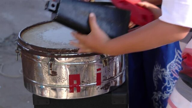 Hands of a Young Boy Putting a Cowbell on his "Timbales" (Drums) on the Street. Close Up.