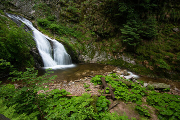 Waterfall with bridge at Allerheiligen waterfall cascade in a landscape shot in nature, Black Forest, Germany.