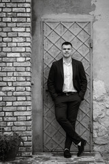 Obraz premium portrait of a young guy groom in a dark wool suit