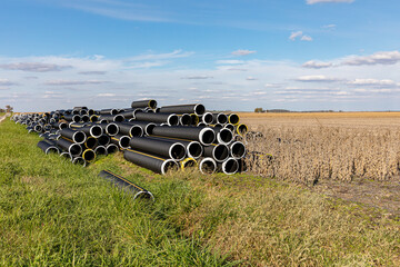 Black plastic field tile pipe in farm field. Flooding prevention, soil conservation and drainage...
