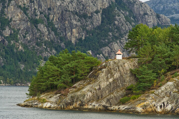 Leuchtturm auf Felsen mit Bäumen und Tannen bei Stavanger - Norwegen