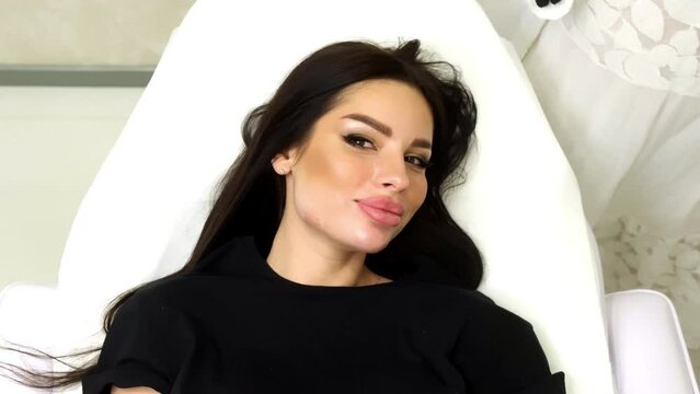 The cosmetologist corrects the shape of the cheekbones by cosmetic injections. The doctor injects hyaluronic acid into the woman's skin as a facial rejuvenation procedure.