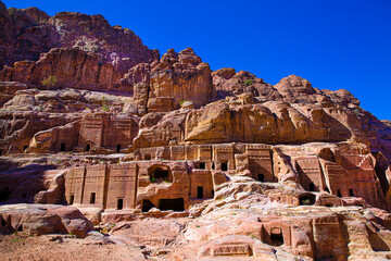 Facades of street of facades, carving in the mointains, Petra, Jordan. Bright blue sky. 