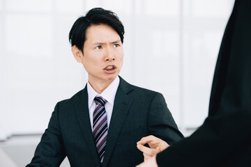 部下を注意する日本人男性ビジネスマン