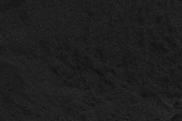 Abstract black sand texture. Dark background of black sand