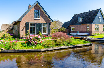 Fototapeta na wymiar View of typical houses of Giethoorn,The Netherlands. The beautiful houses and gardening city is know as 